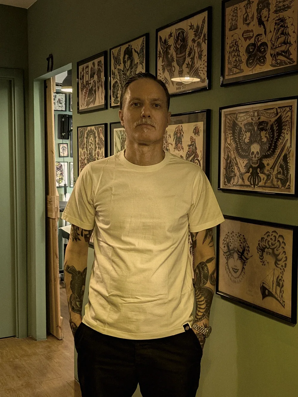 Leo Martínez, full length, in the corridor of A Sailor's Grave Tattoo, his private studio in Granollers (Barcelona).