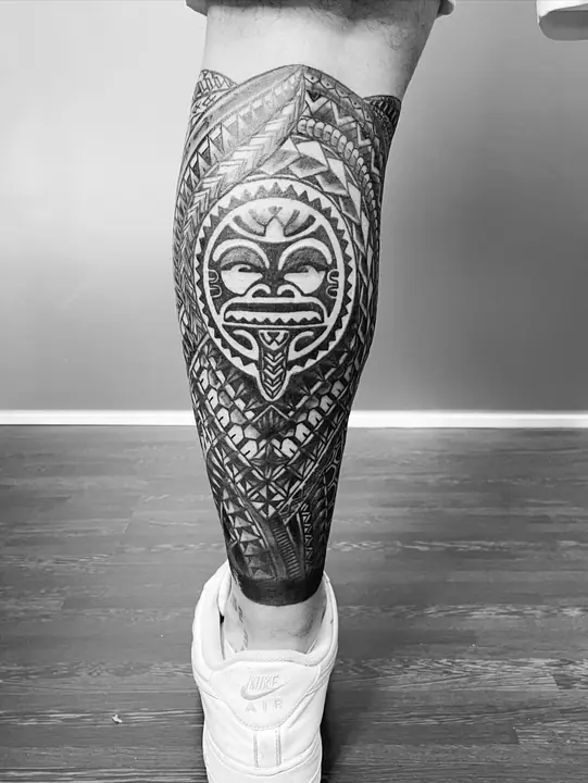 Máscara tiki en el gemelo — tatuaje polinesio realizado por Leo Martínez en Koru Tatau · A Sailor's Grave Tattoo, Granollers (Barcelona).